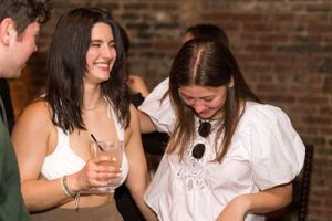Friends sharing laughs during a casual gathering at a brick-walled venue.