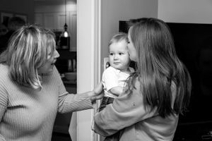 Black and white photo of three generations sharing an intimate moment indoors.