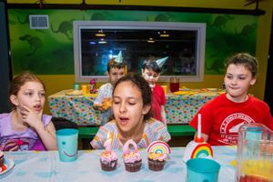 Birthday party celebration with cupcakes and colorful decorations at a kids party venue.