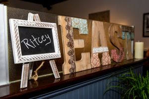 Decorative wooden letters spelling 'Fresh' with a small chalkboard sign on a shelf.