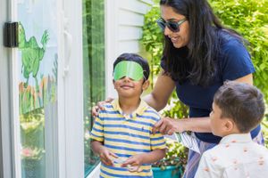 Group participating in outdoor blindfolded sensory activity during summer day.