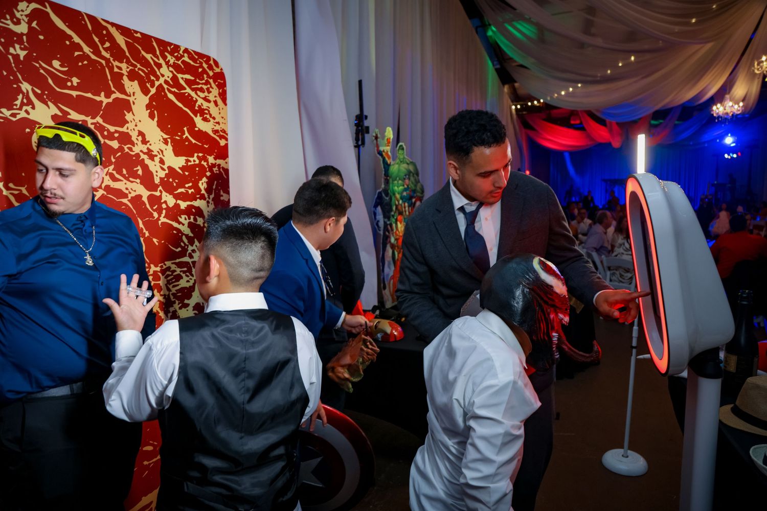 Reception party guests enjoying an arcade game setup at a wedding celebration.