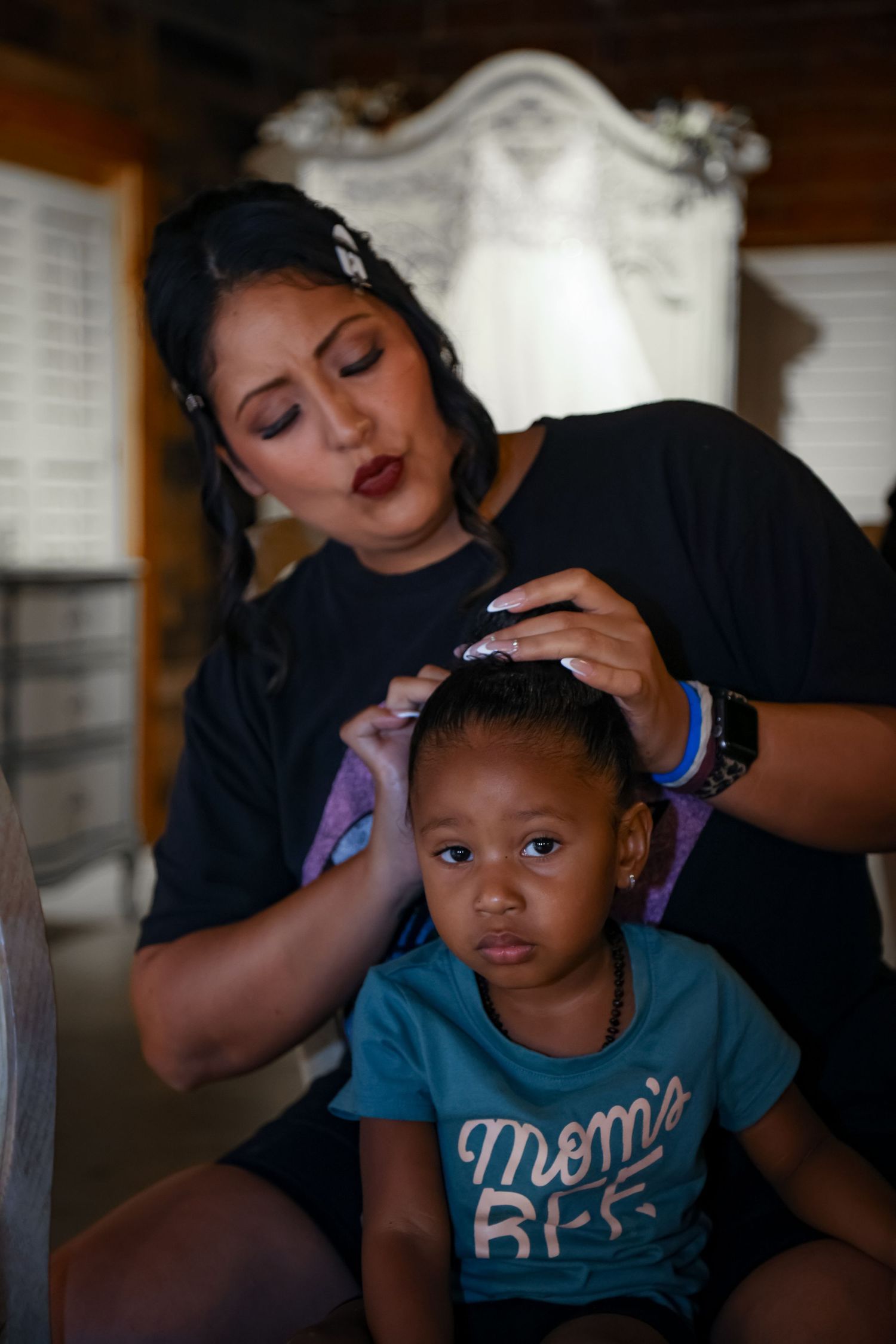 A touching moment during wedding preparations as hair is being styled.