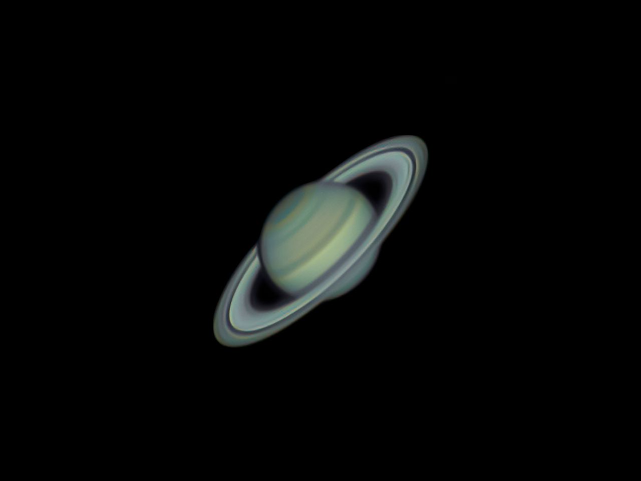 Saturn with its iconic ring system captured in vivid color through a telescope.
