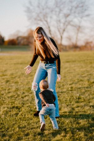 A heartwarming moment of play in a sunlit grassy field.