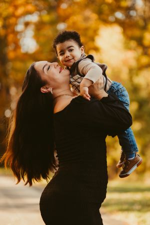 Parent and child sharing a joyful moment outdoors during autumn.
