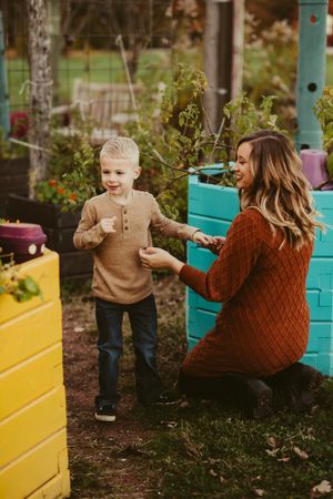 Playful moment in colorful garden with teal and yellow painted storage boxes.