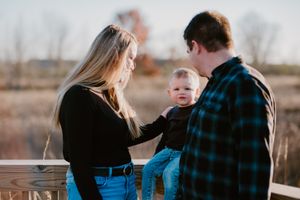 Family sharing an intimate moment together outdoors during golden hour.