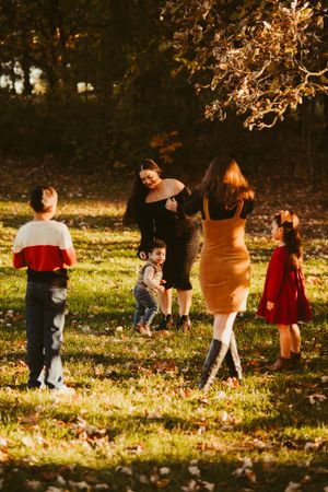 Group enjoying a sunny autumn day outdoors with fall foliage in the background.