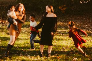 Playful scene of people dancing and having fun in a sunlit autumn park.
