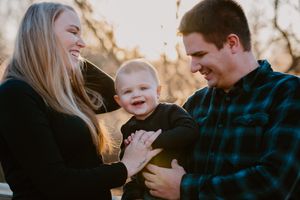 A joyful family sharing laughs together during golden hour outdoor photography session.
