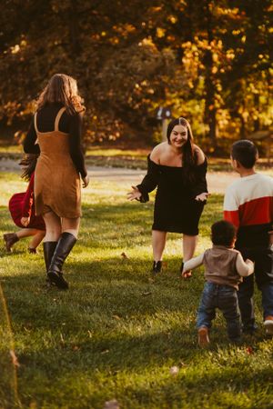 Group playing and running together in a sun-drenched autumn park.