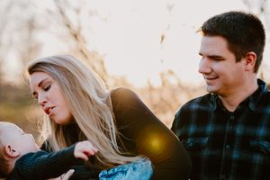 A tender family moment captured during sunset with autumn colors in the background.