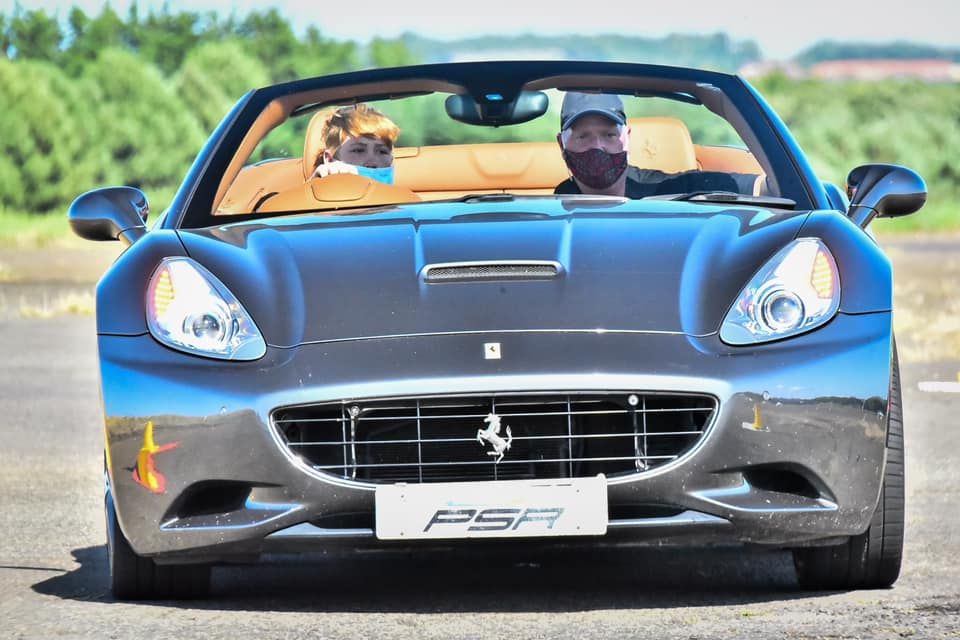 Sleek gray Ferrari California convertible sports car on track.