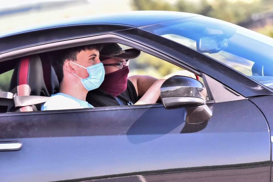 Person driving car while wearing protective face mask.