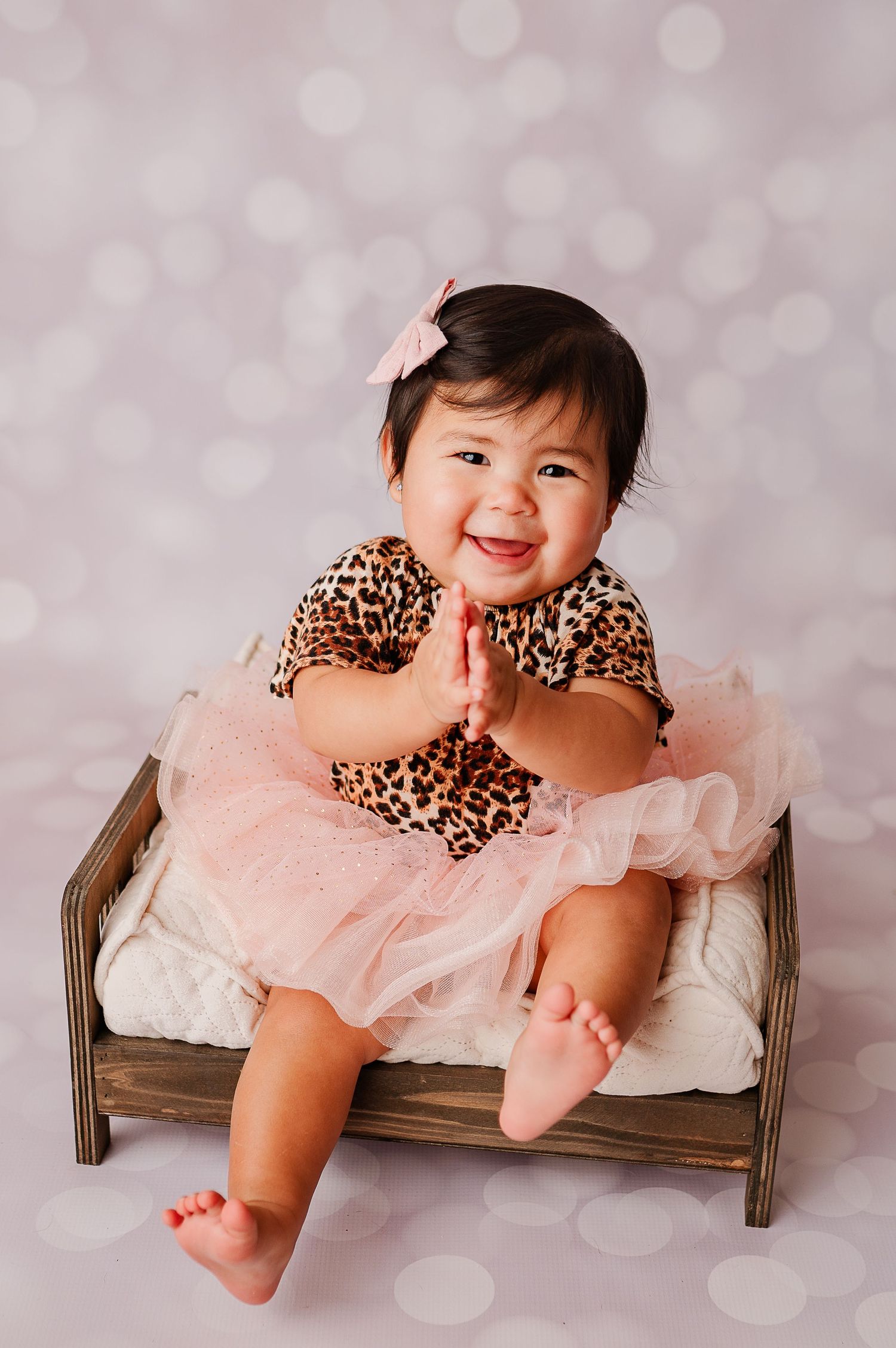 One year old clapping during her cake smash photoshoot