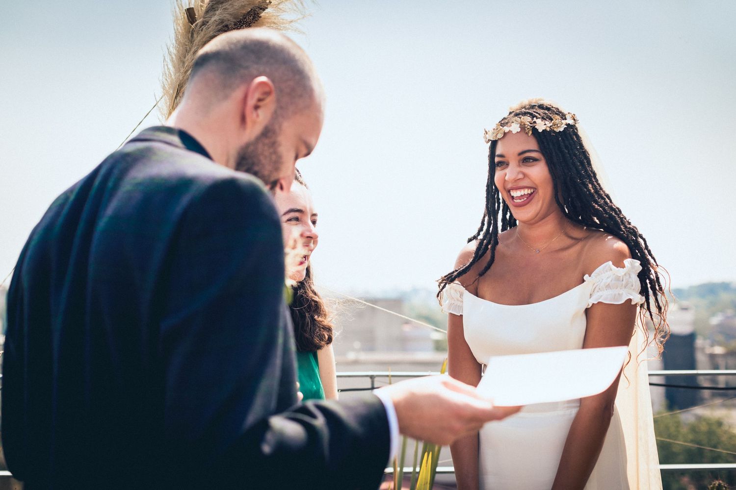 Social gathering on a rooftop with attendees in formal attire sharing drinks and laughter.