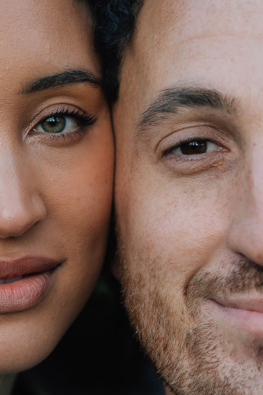 Extreme close-up half-face portrait of interracial couple side by side showing eyes.