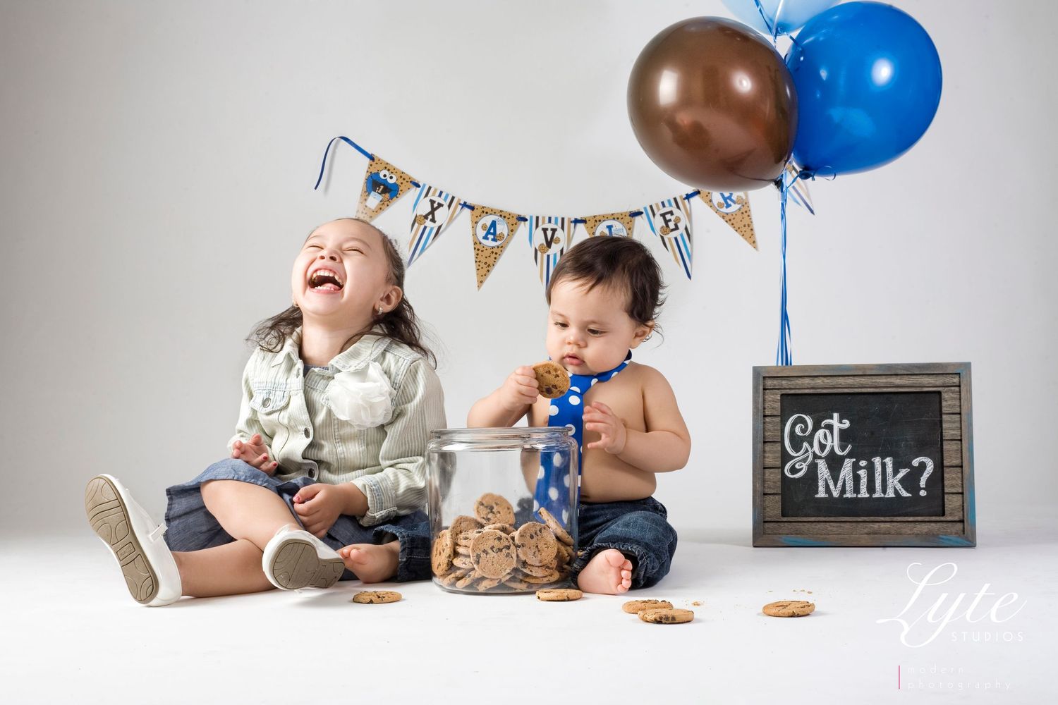 two small children on top of balloons and cookies, in the style of object portraiture specialist, light brown and navy