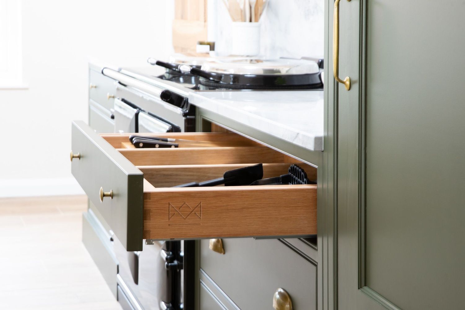 Close-up of wooden kitchen drawer organizers showing detailed storage compartments.
