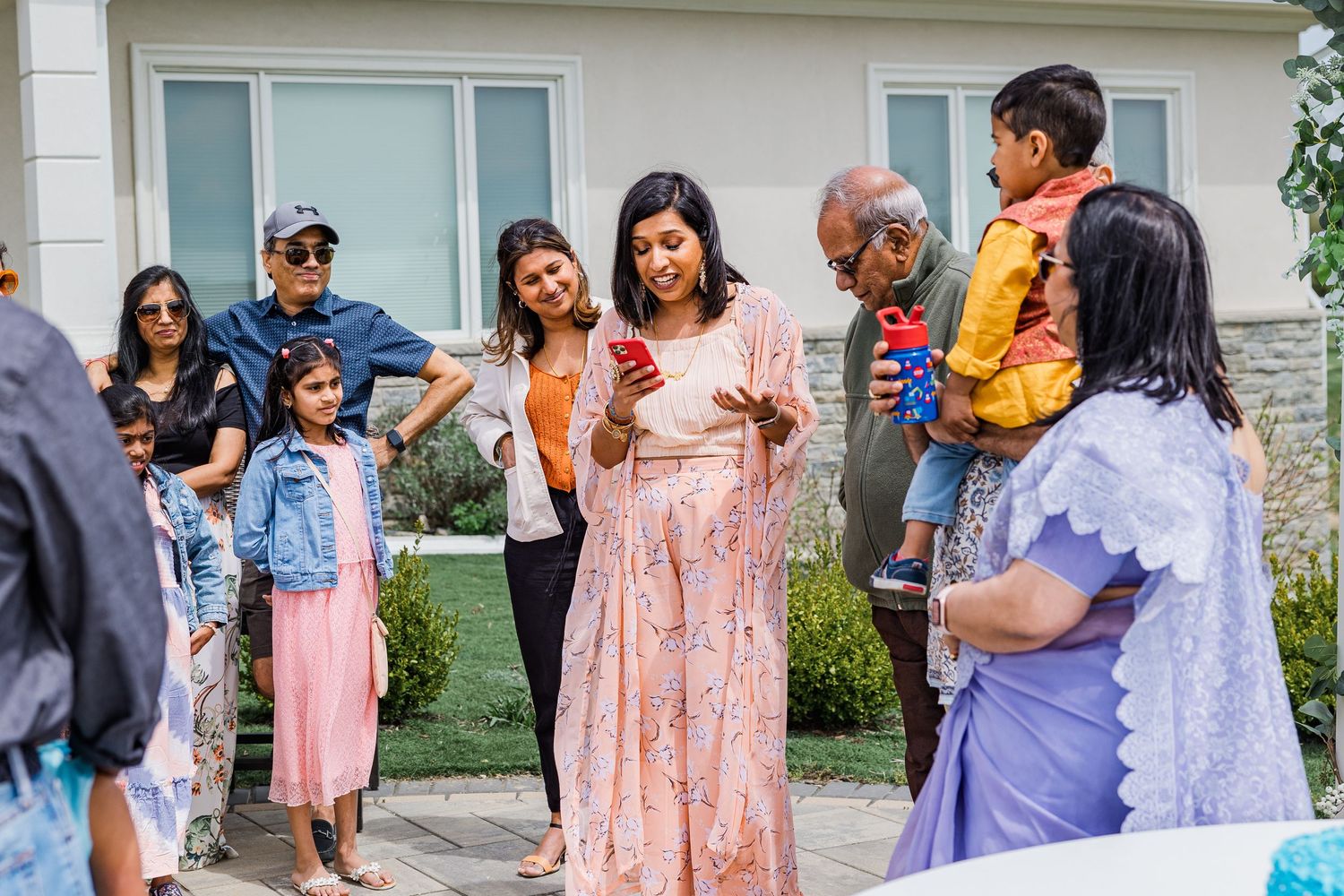 Group of people gathered outdoors for a celebration, wearing festive attire.