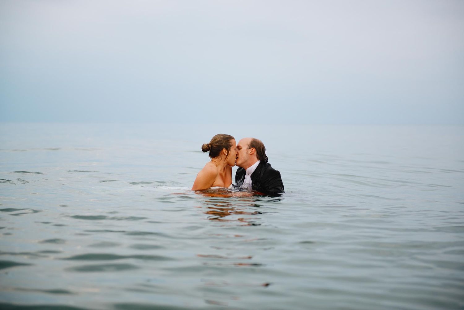 A couple sharing an intimate moment while swimming in the ocean.
