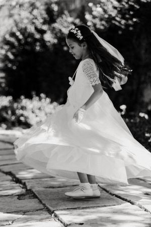 Black and white image of a flowing white dress twirling on stone pavement.