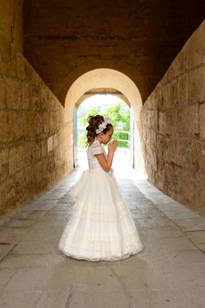 Wedding couple poses for romantic photos in a stone archway tunnel with natural lighting.