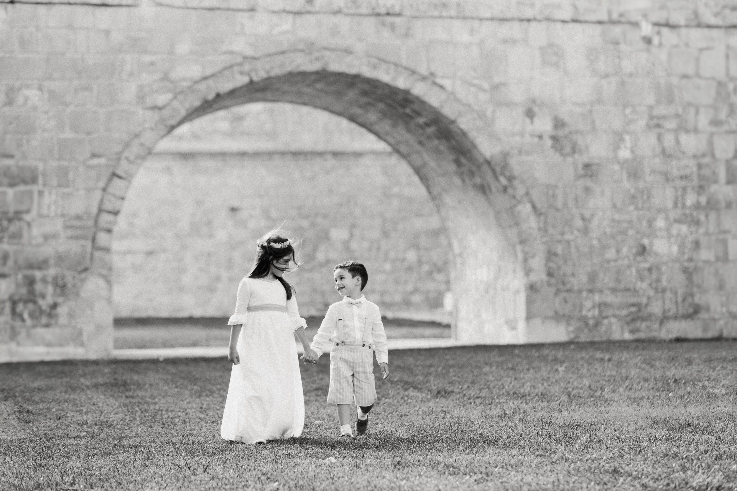 Family silhouettes against stone wall with arched openings.