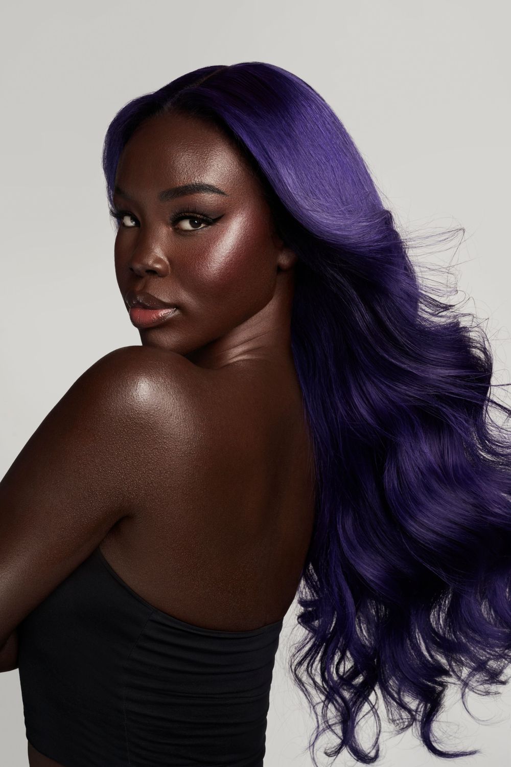 Stunning beauty portrait with flowing purple hair and luminous skin.