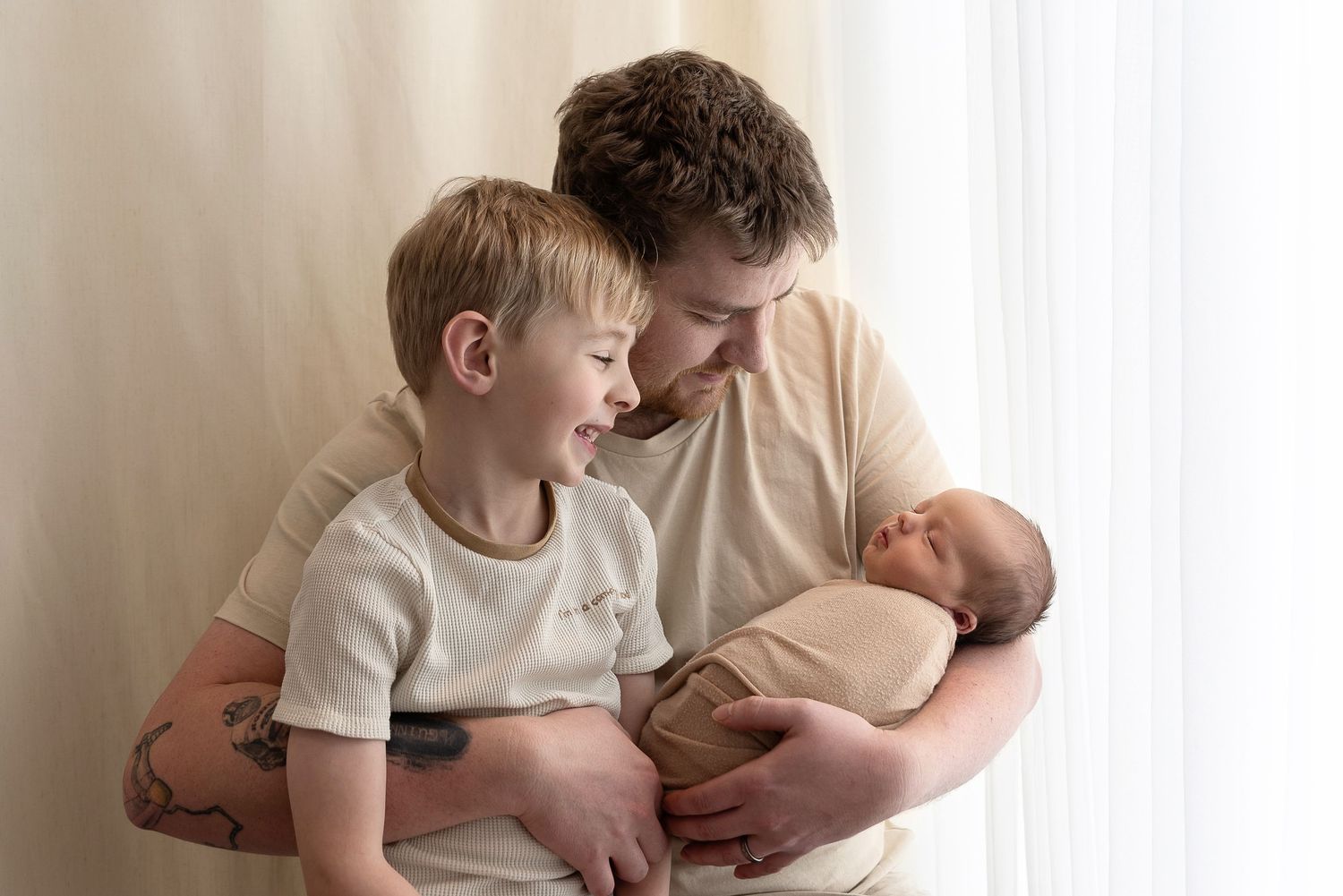 A loving family moment showing a parent and siblings bonding together in soft window light.