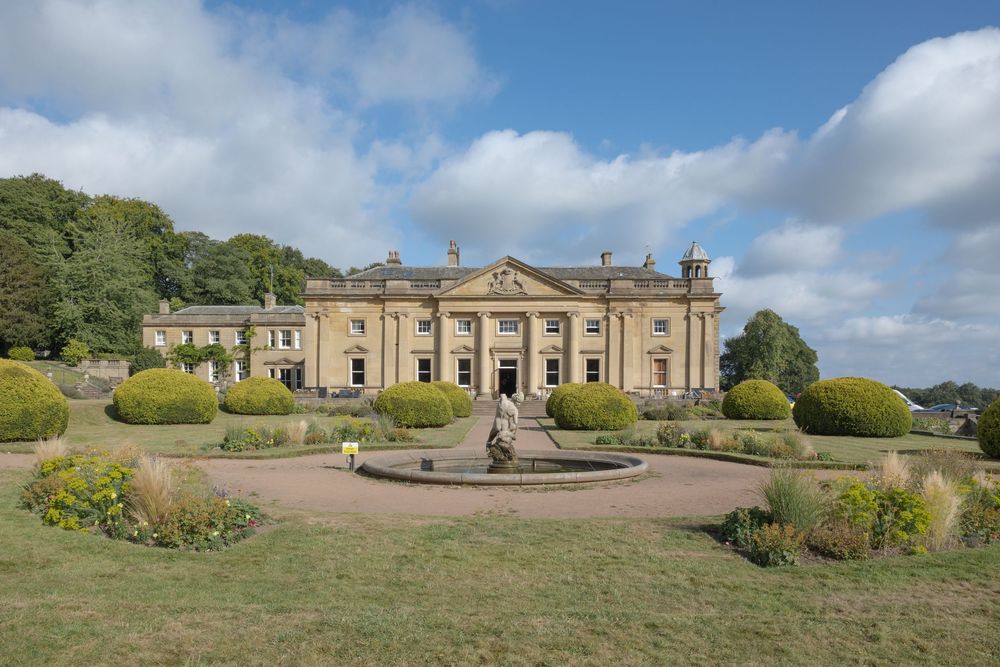 Elegant English country manor house Wortley Hall Sheffield, manicured gardens and circular driveway featuring ornate fountain centerpiece.