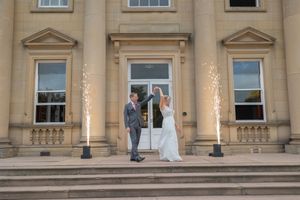 Elegant beige stone building exterior with classical architectural details and multiple windows in symmetrical arrangement.