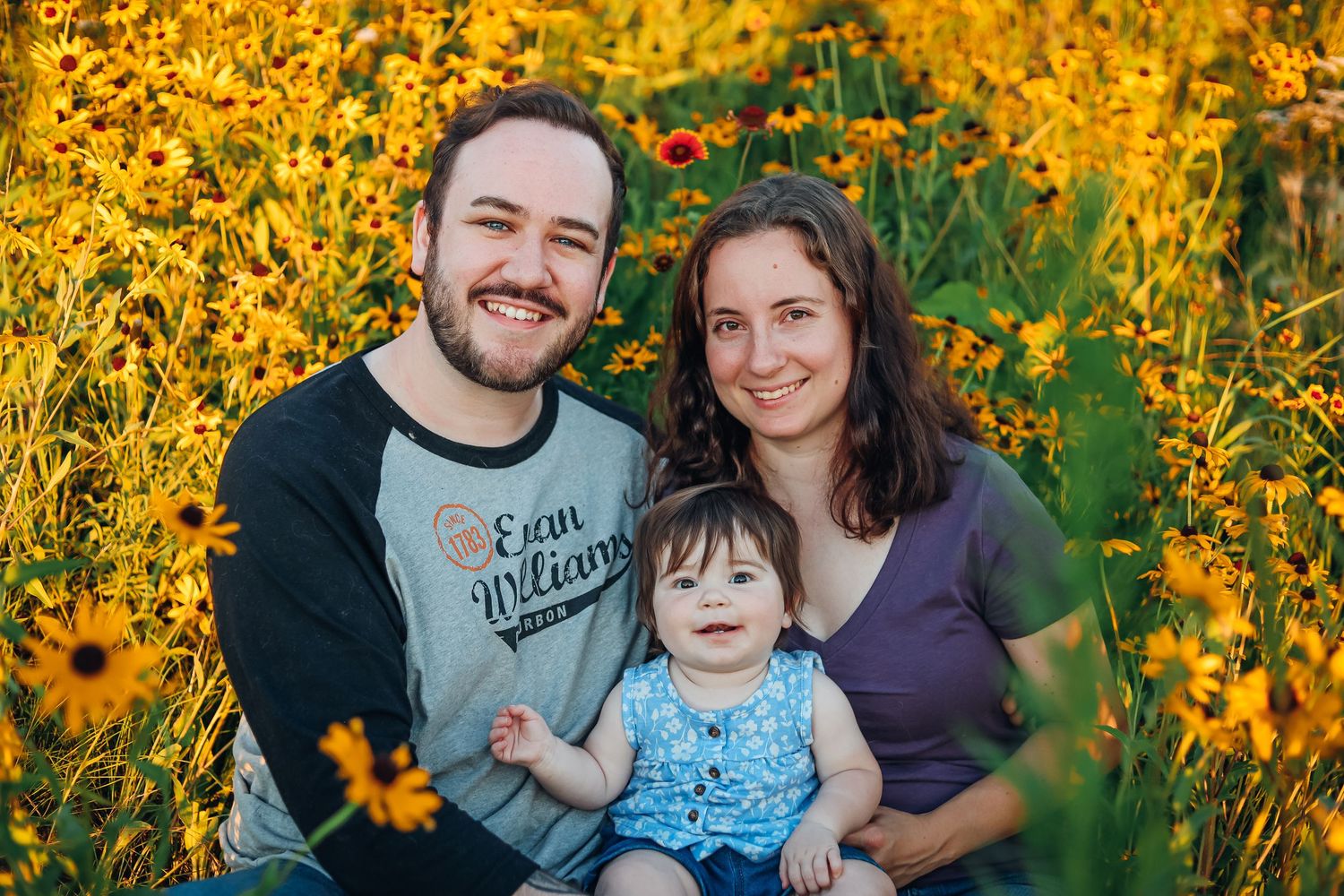 A family portrait among vibrant yellow wildflowers on a sunny day. Family photography