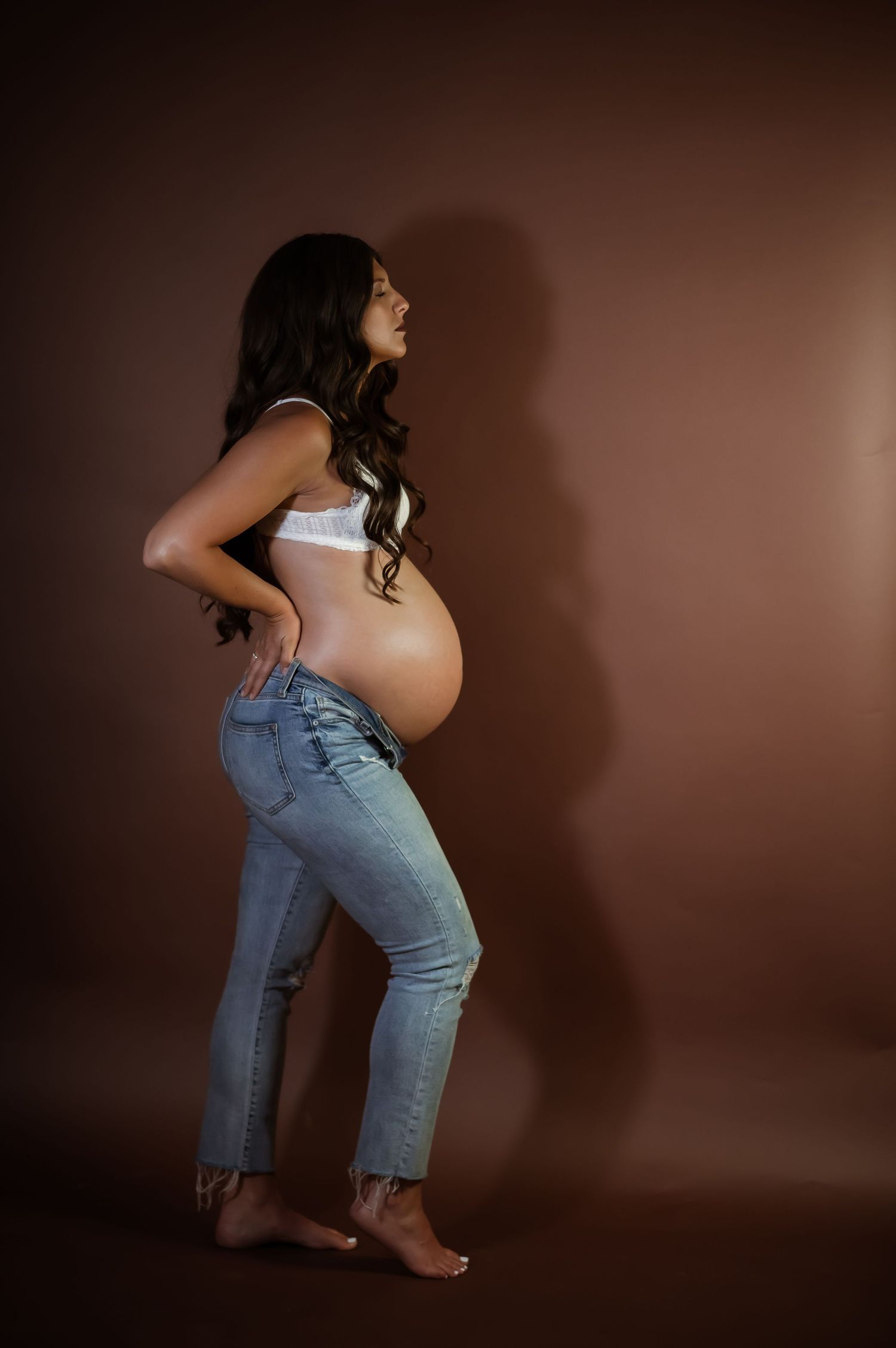 Artistic silhouette portrait against brown backdrop in denim.