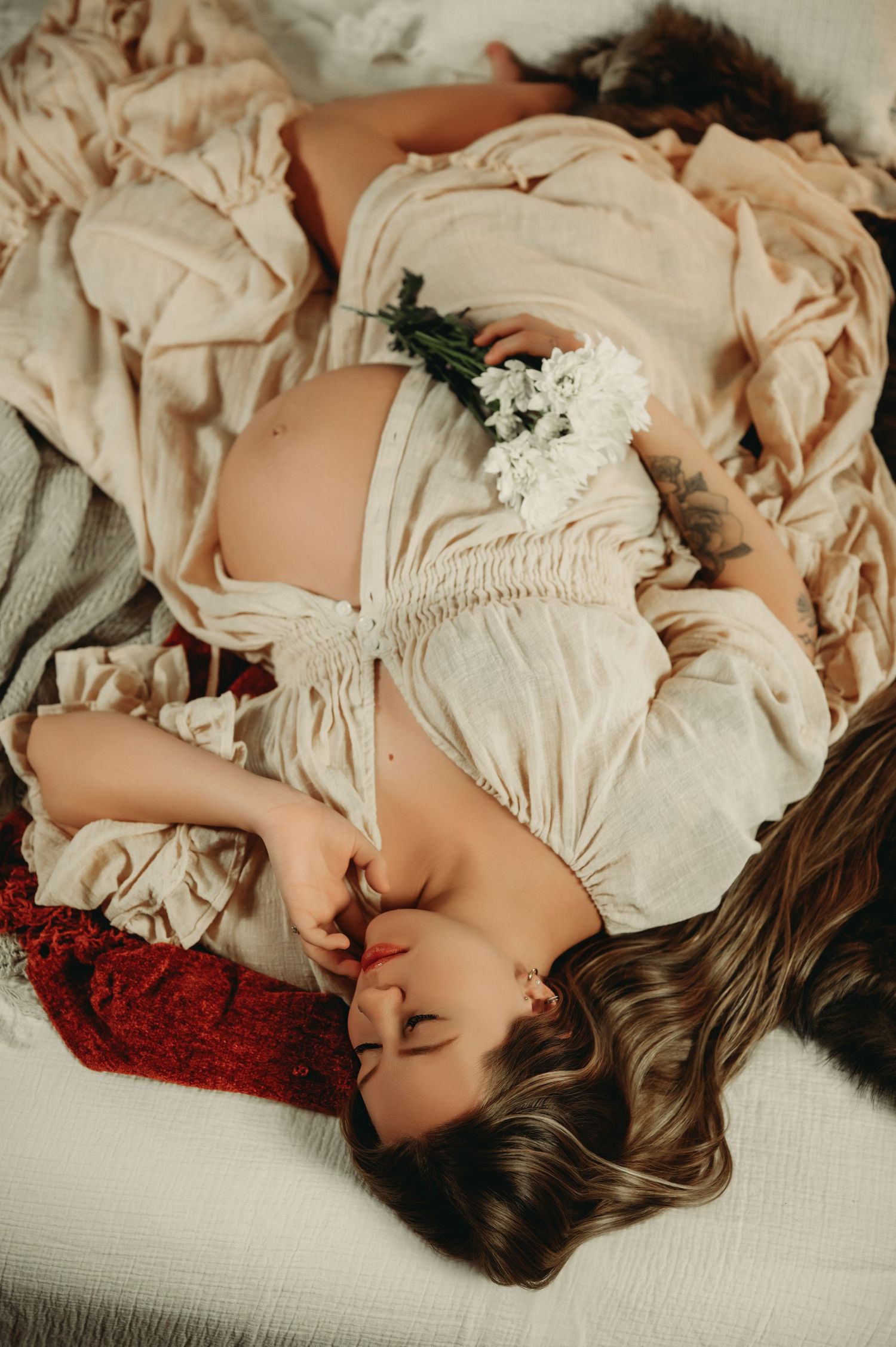 A dreamy portrait series of a person lying down in vintage-style cream clothing against a red and white background.