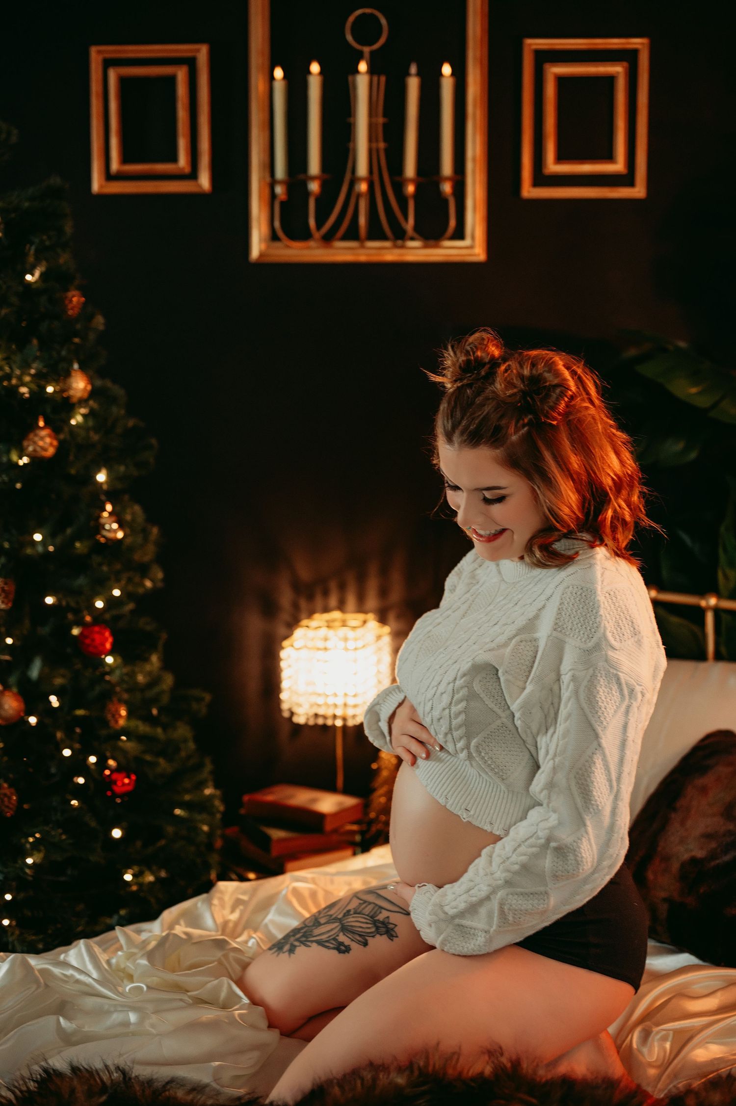 Intimate holiday boudoir photo with white sweater and Christmas tree in background.