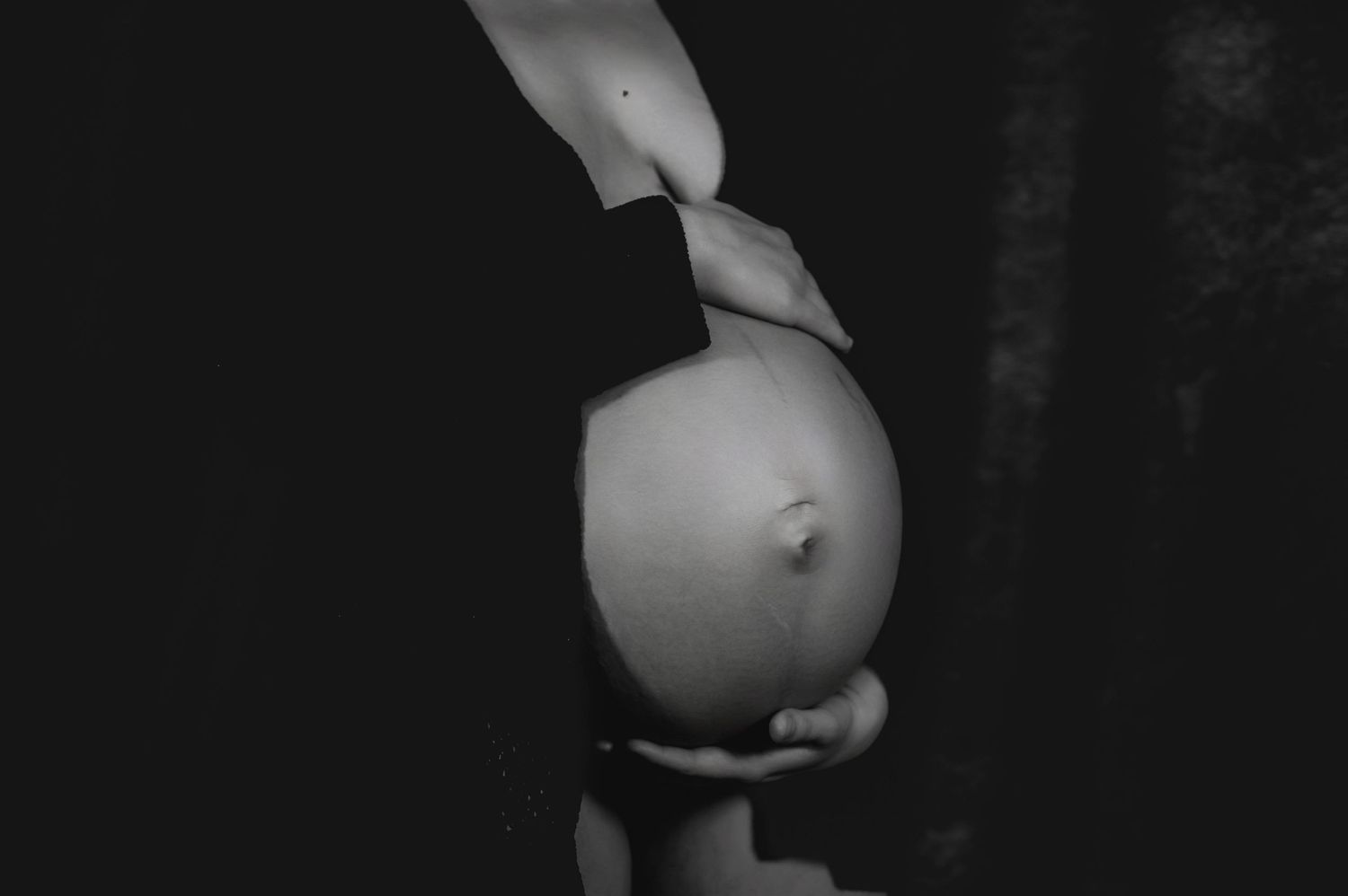 Black and white maternity silhouette highlighting the pregnant form.
