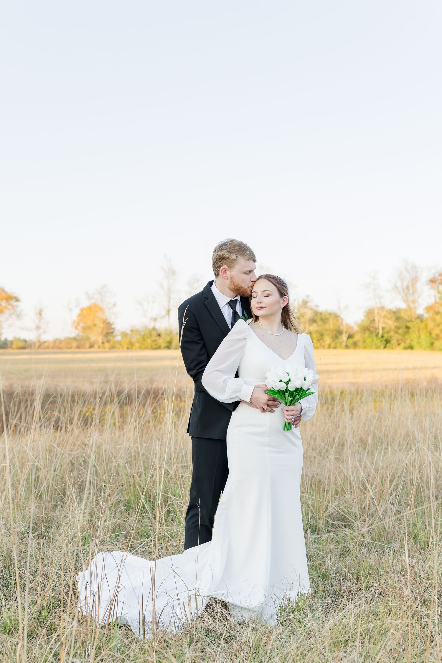 groom kissing the bride and holding each other in their wedding day