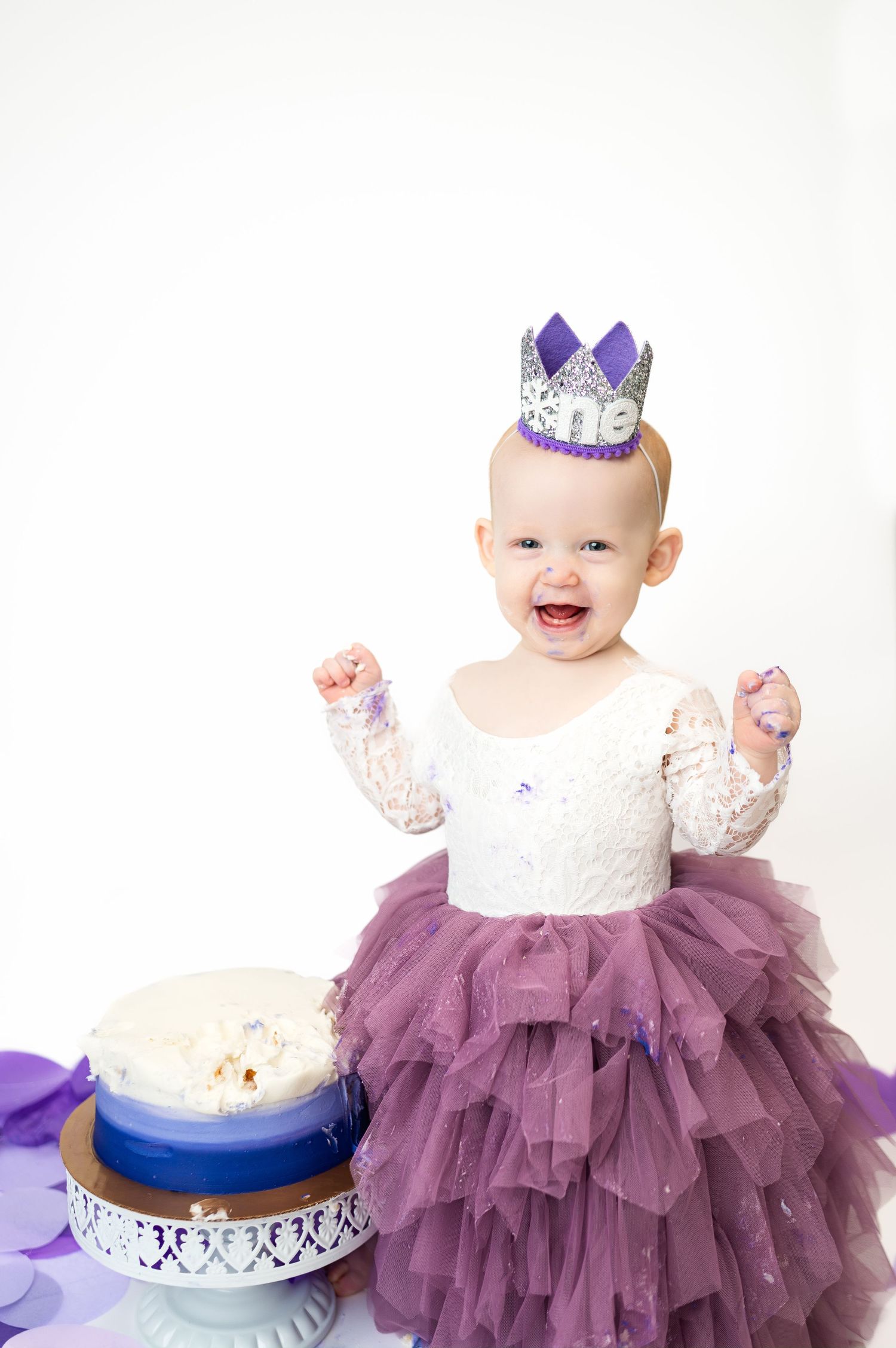 girl stands next to cake during dallas area one year cake smash milestone in-home photo session