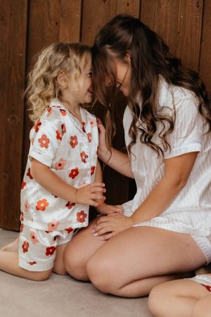 A tender moment shared between two people sitting together wearing floral and white outfits.