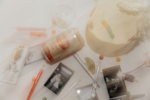 Wedding details including polaroid photos, candles and decorative elements arranged on a light surface.