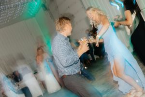 A proposal moment captured during a dance with turquoise lighting effects.