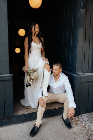 Stylish wedding portrait with warm lighting against dark doorway.