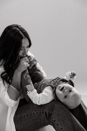 A black and white photo sequence showing a couple sharing intimate moments and laughter while lying down together.