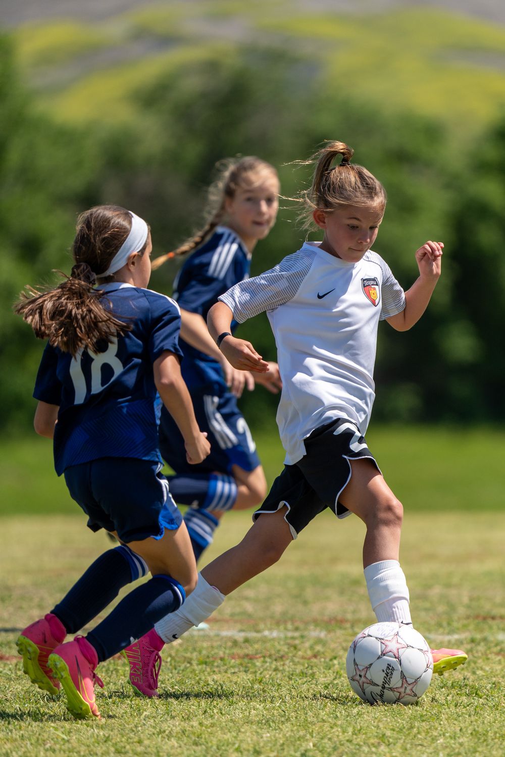 Girl playing soccer in Fort Worth, Texas, showcasing skills and enthusiasm on the field.