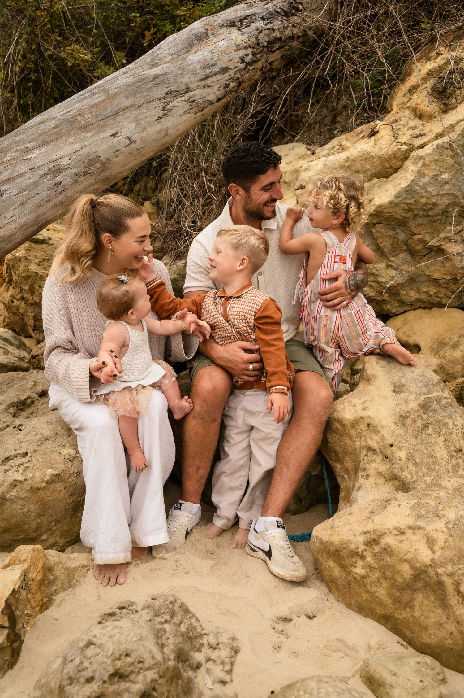 Happy family shares a joyful embrace against an outdoor backdrop.