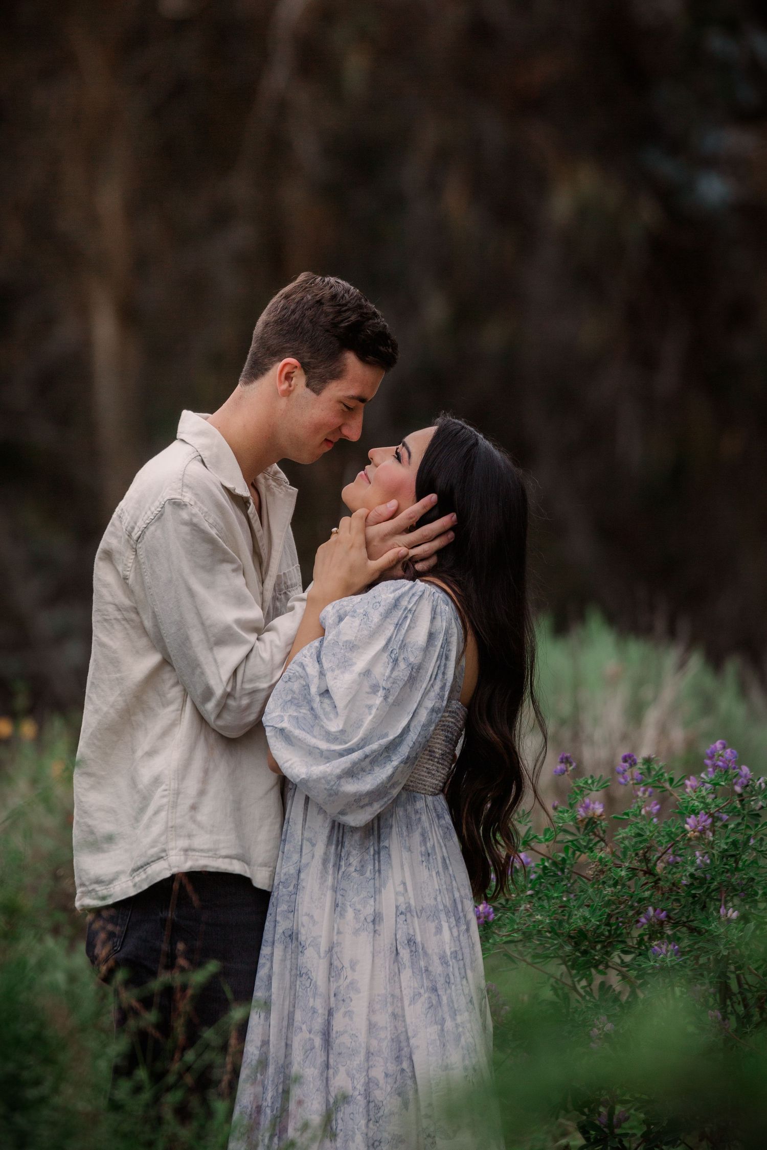 A romantic couple embraces in a field of purple wildflowers at dusk, captured in a series of intimate moments.