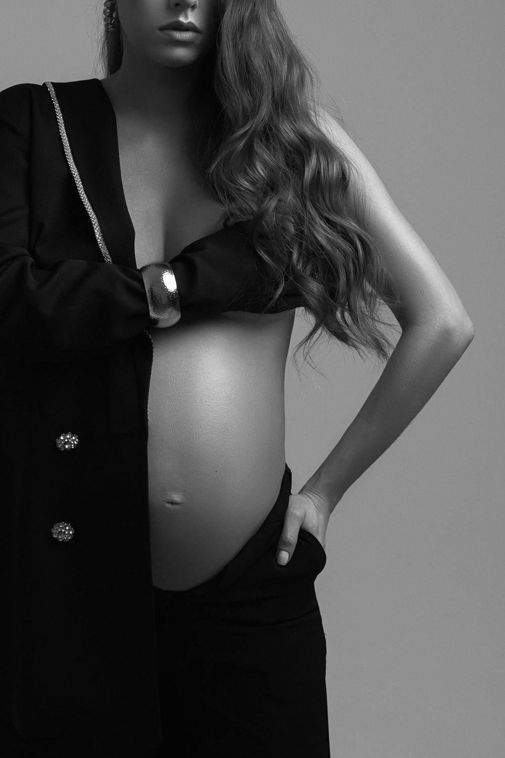 High contrast black and white maternity photo showing pregnancy silhouette.