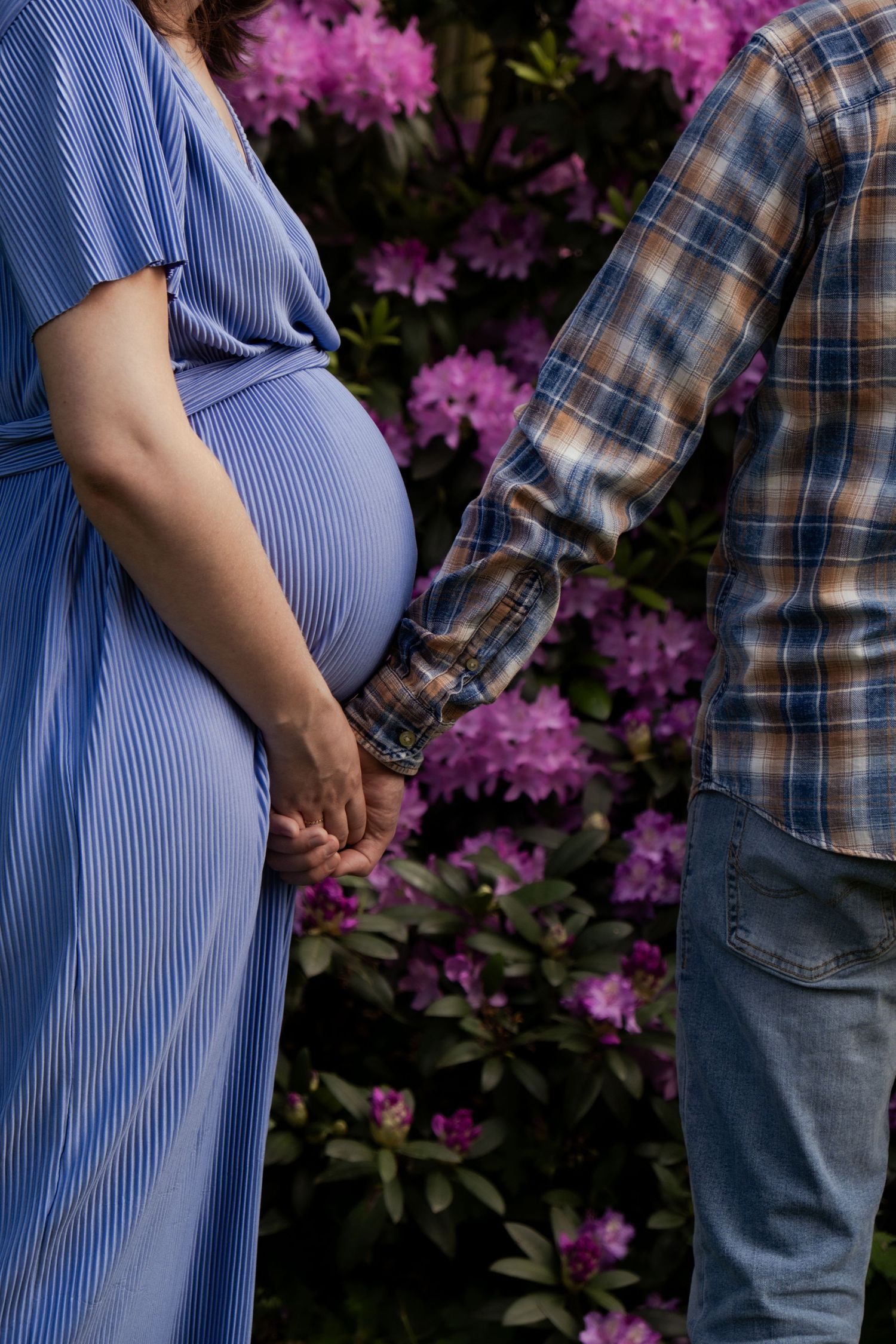 Portretfoto van zwangere vrouw met partner voor bloemen